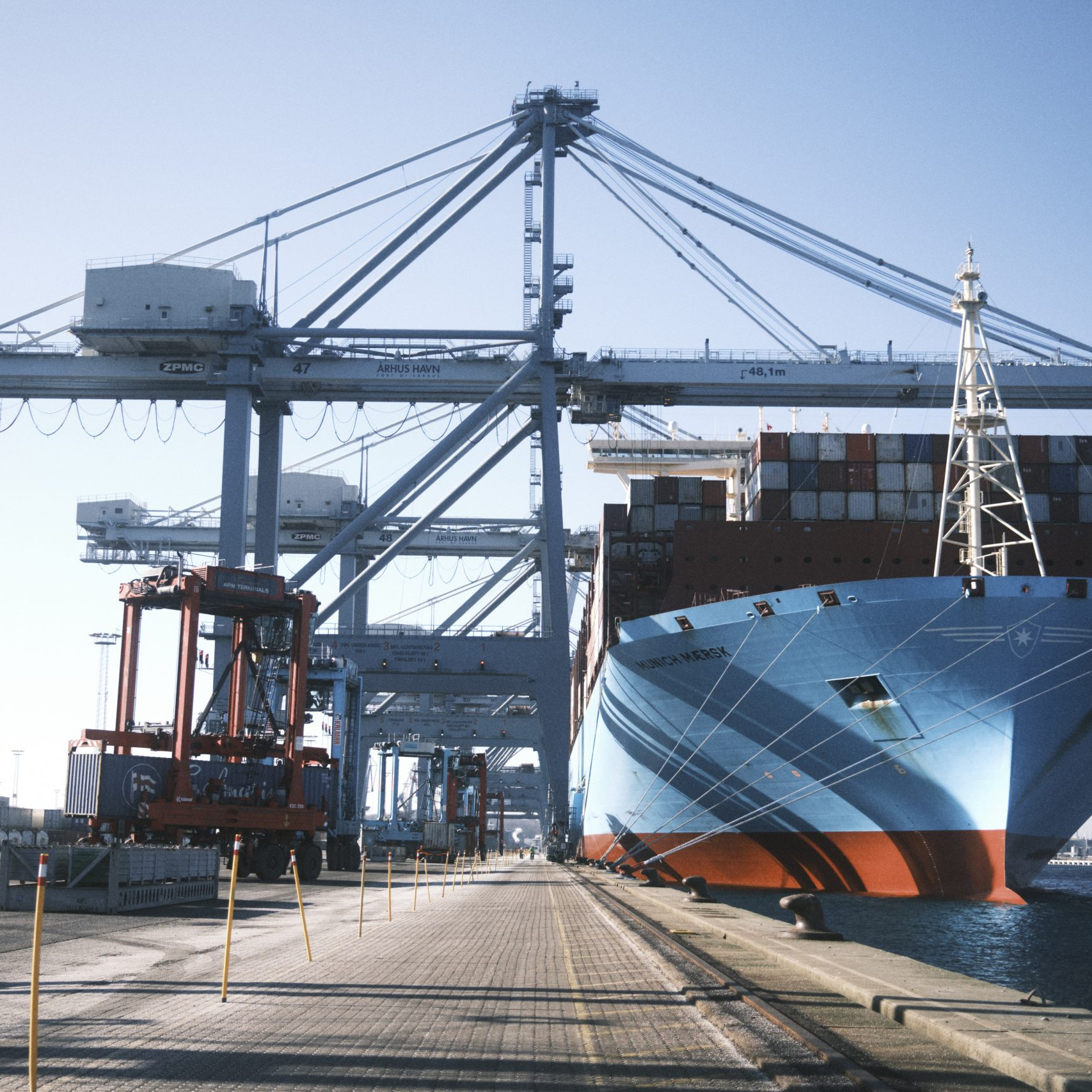 Stort lastskib ved kajen med containerkraner