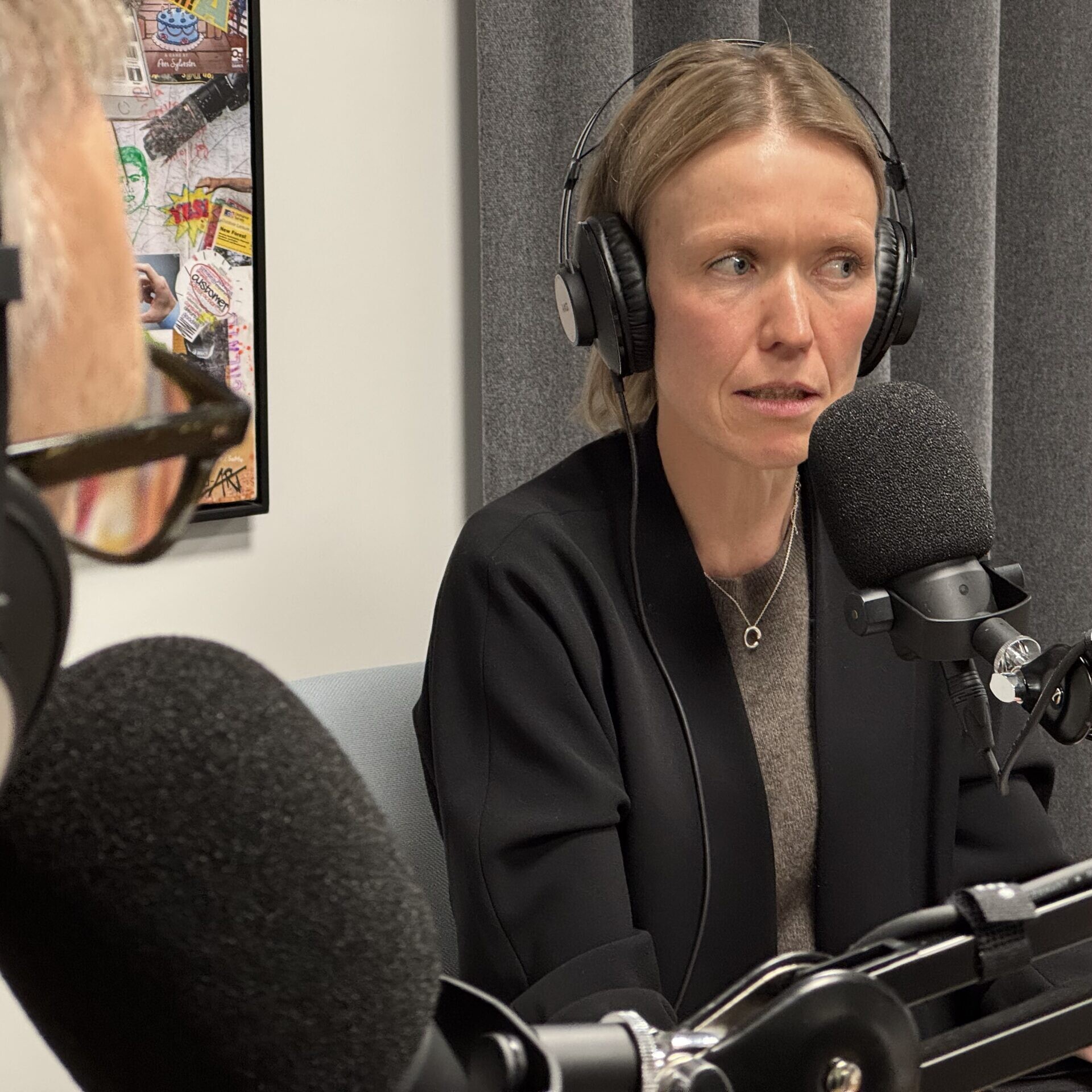 Kvinde med hovedtelefoner taler i mikrofon under podcast optagelse